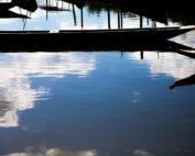 Fotografia de canoas e seus reflexos.